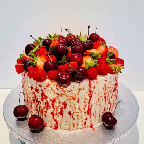 Fruits topped Vanilla sponge cake with raspberry jam and buttercream layers