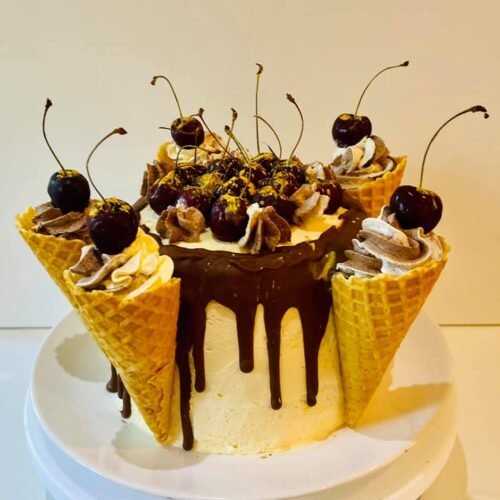 Chocolate Vanilla Sponge Cake with Buttercream and Raspberry Jam Layer, decorated with fresh Cherries