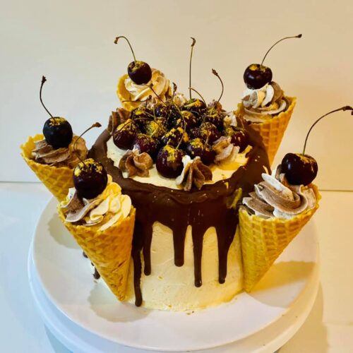 Chocolate Vanilla Sponge Cake with Buttercream and Raspberry Jam Layer, decorated with fresh Cherries