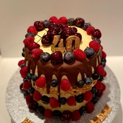 Chocolate Cake with Buttercream filling, decorated with Chocolate drops and Fresh Seasonal Fruits